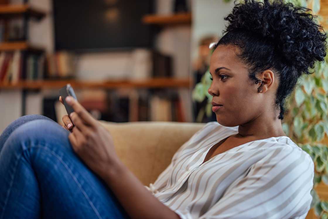 A curious woman checking her phone A curious woman checking her phone