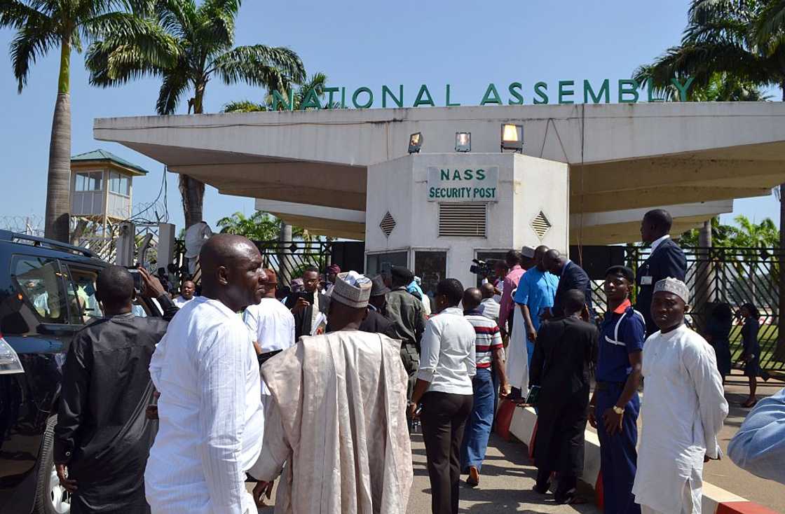 Nigerian parliament members gather at the national assembly gate