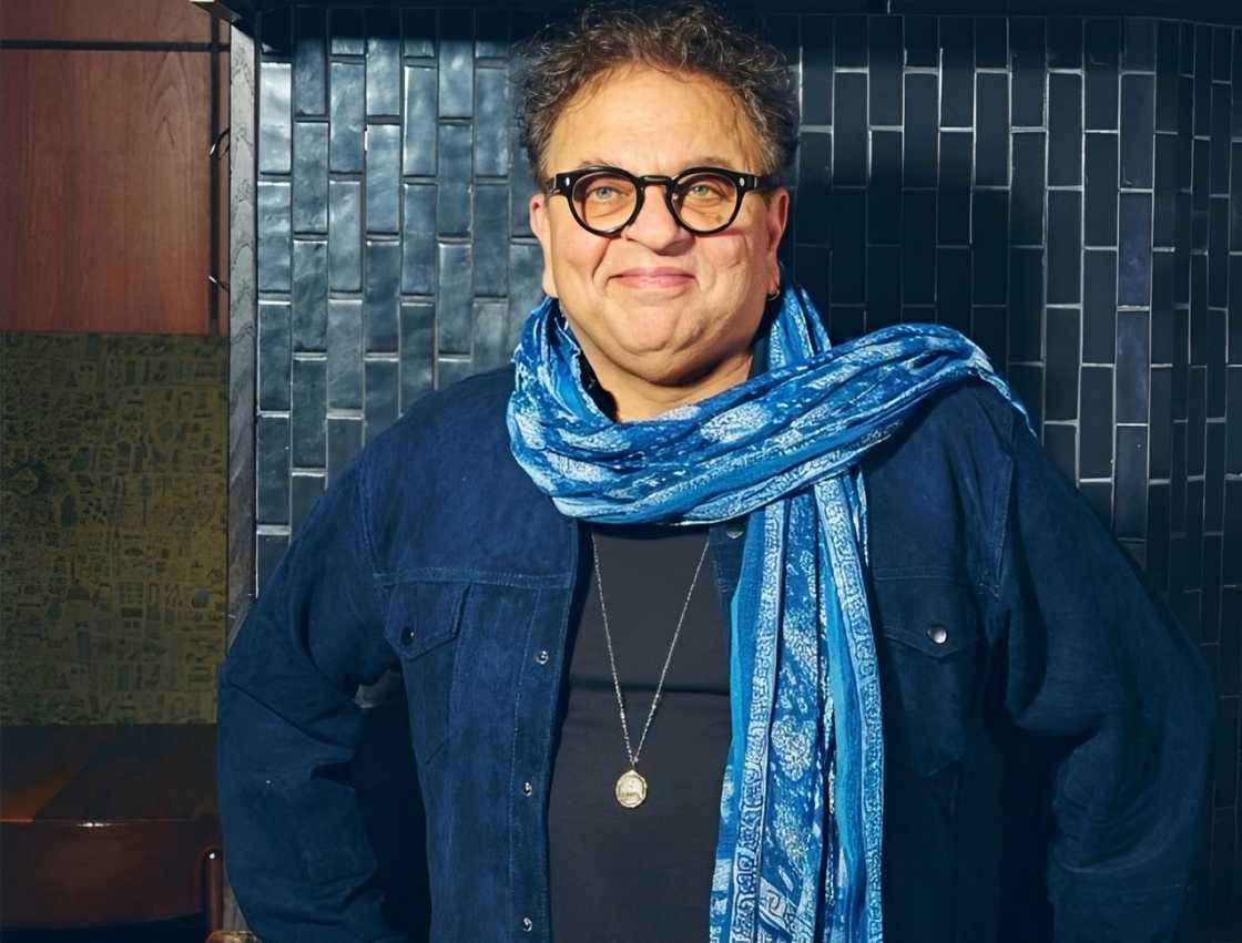 Chef Vikram Vij poses against a tiled wall