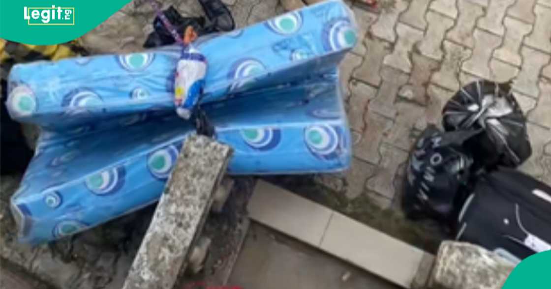 Nigerian man displays the foodstuffs that a year 1 student brought to school.