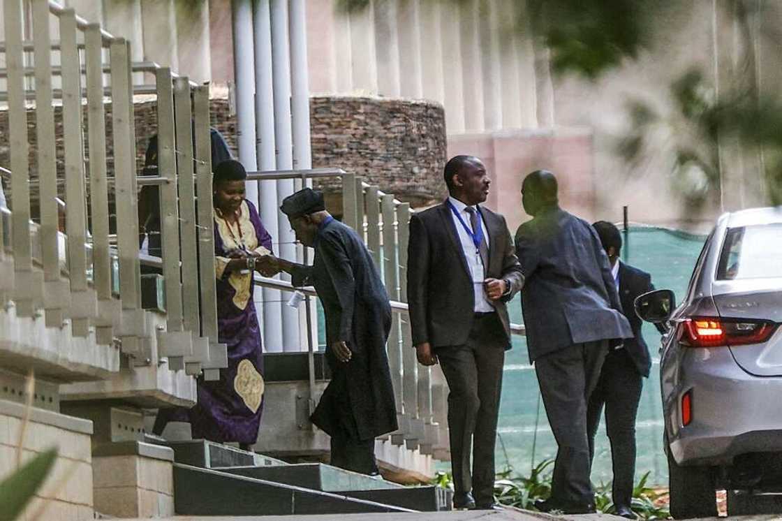 African Union envoy and former Nigerian president Olusegun Obasanjo, wearing a cap, is greeted on the second day of Ethiopian peace talks