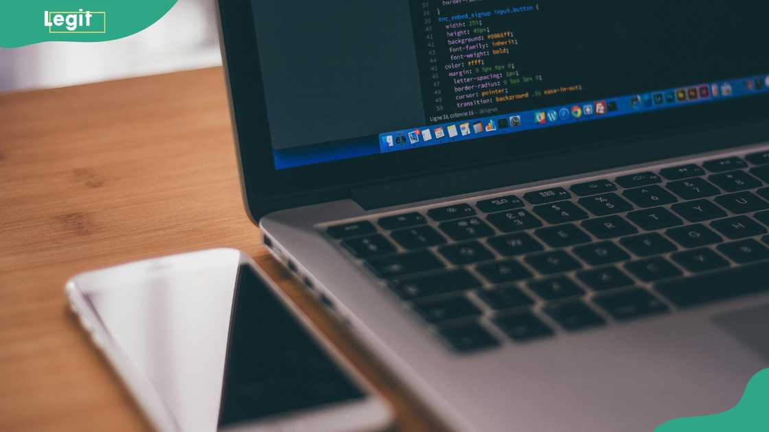 A white Android smartphone near a grey laptop computer A white Android smartphone near a grey laptop computer