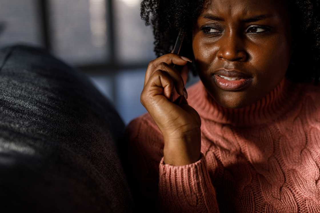 A worried young woman talking on the phone A worried young woman talking on the phone