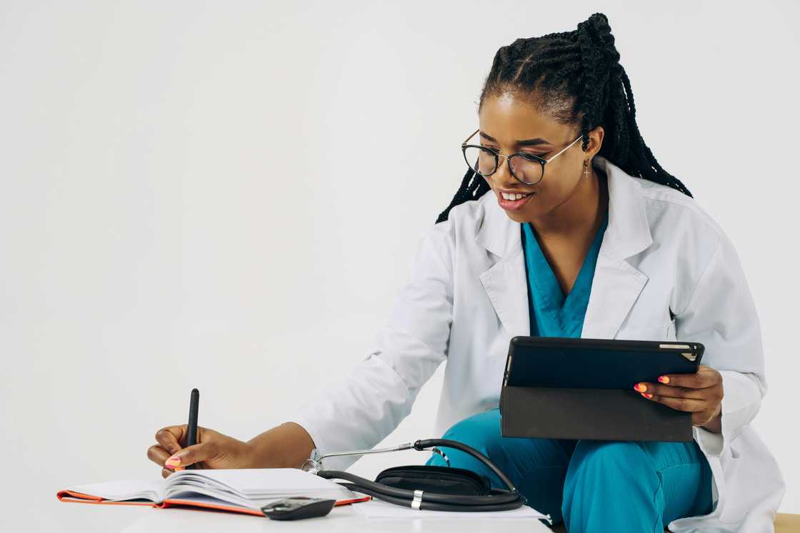 A female doctor writes in a book