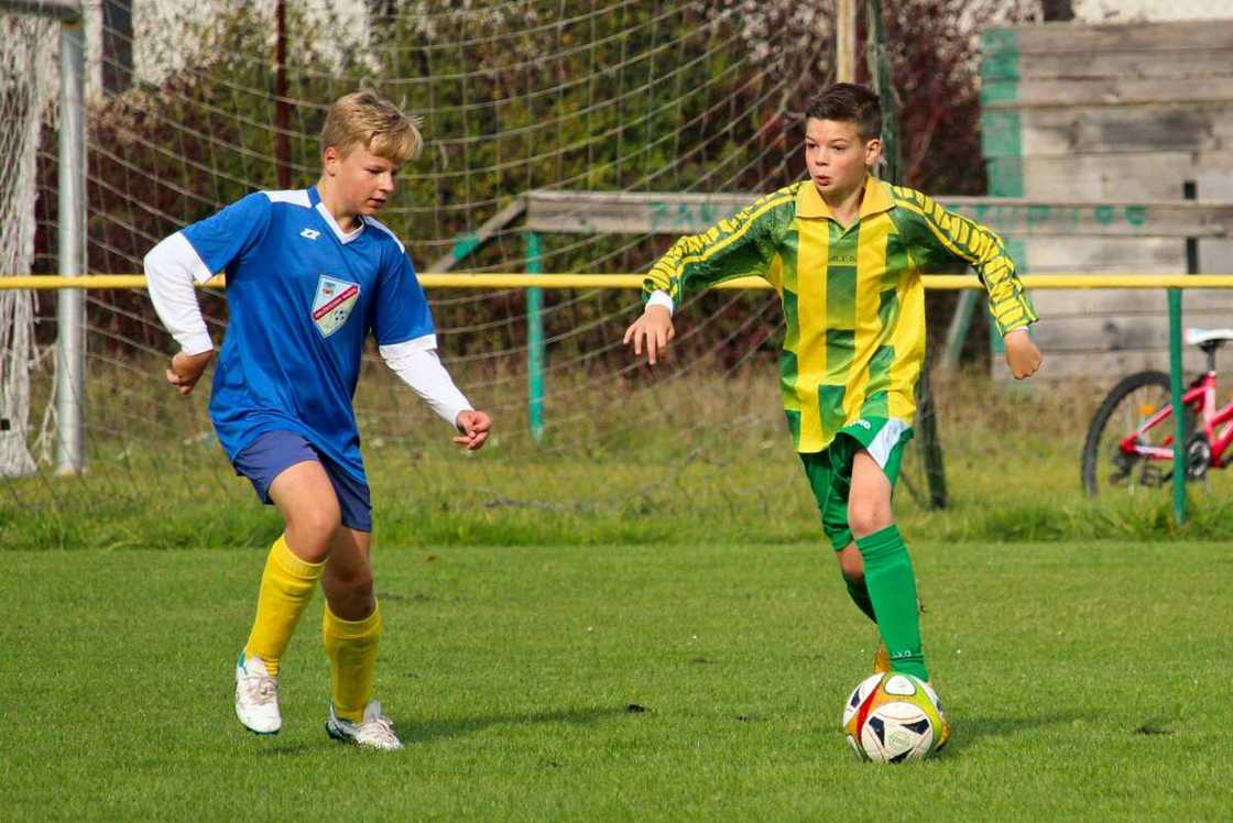 Two boys playing football.