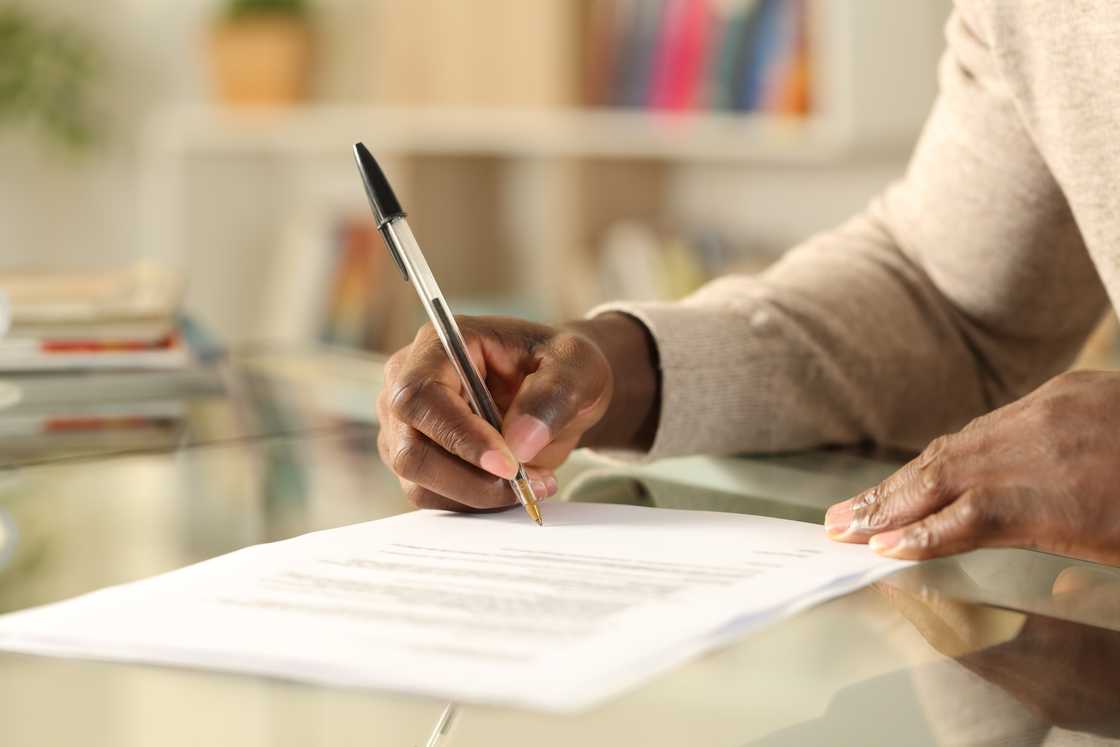 A person filling out a form A person filling out a form