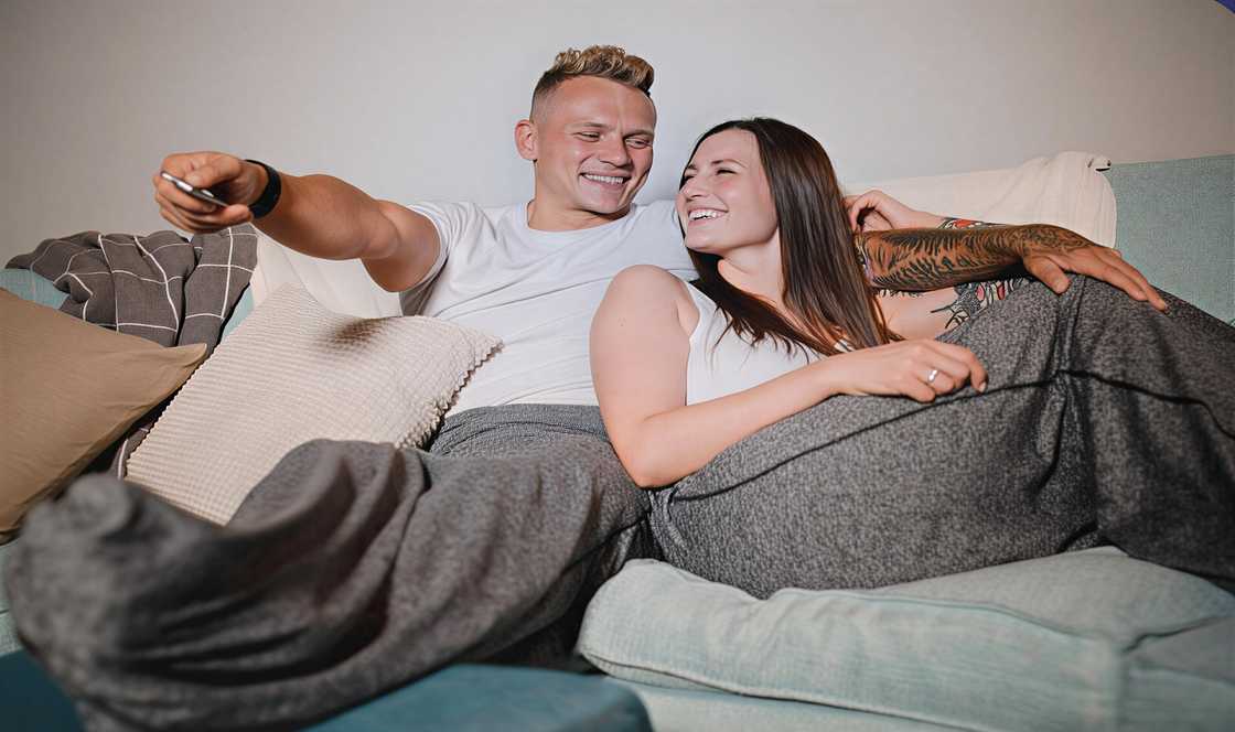 A couple on the couch wearing the Sleep Pod while watching TV A couple on the couch wearing the Sleep Pod while watching TV