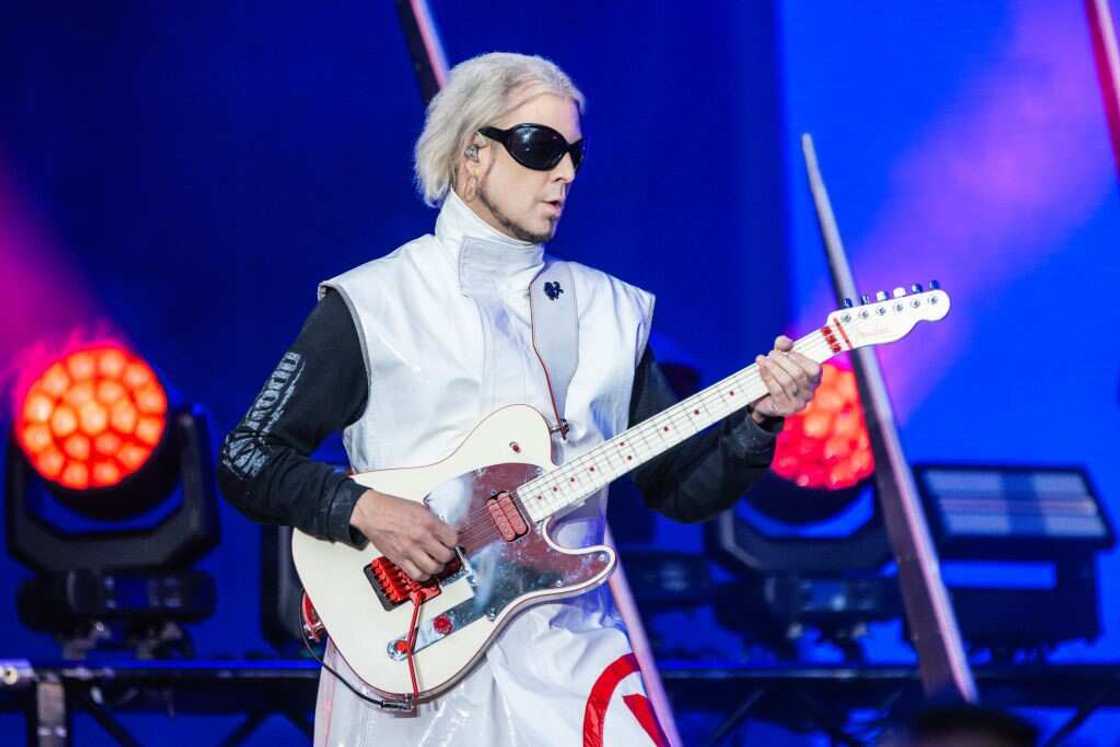 John 5 of Motley Crue playing guitar on stage in a white and black outfit John 5 of Motley Crue playing guitar on stage in a white and black outfit