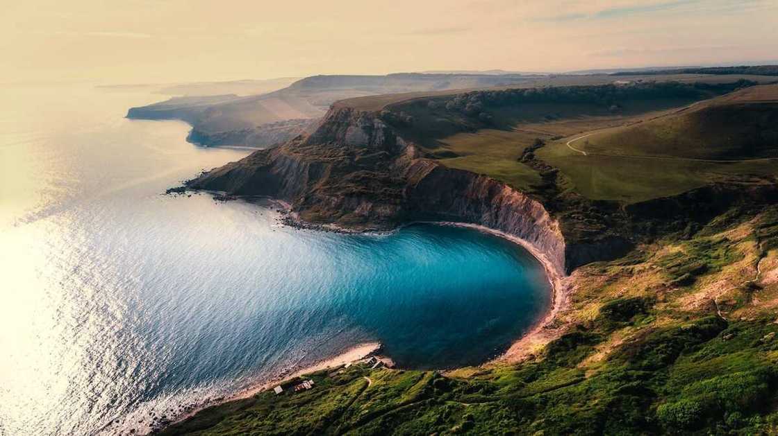 A large water body beside a hilly land