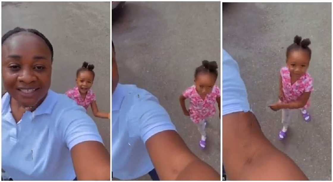 Photo of a black girl standing at the back of an adult. Photo of a black girl standing at the back of an adult.
