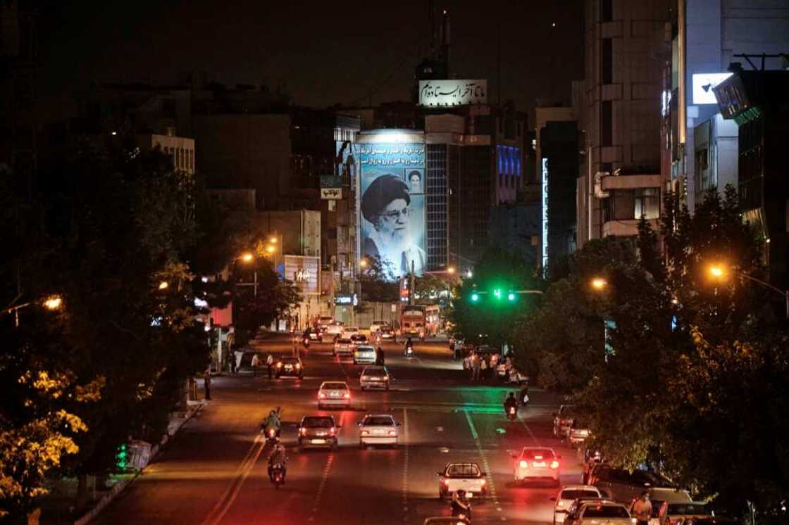 A banner depicting Iran’s Supreme Leader Ayatollah Ali Khamenei is illuminated in downtown Tehran on June 20, 2021 A banner depicting Iran’s Supreme Leader Ayatollah Ali Khamenei is illuminated in downtown Tehran on June 20, 2021