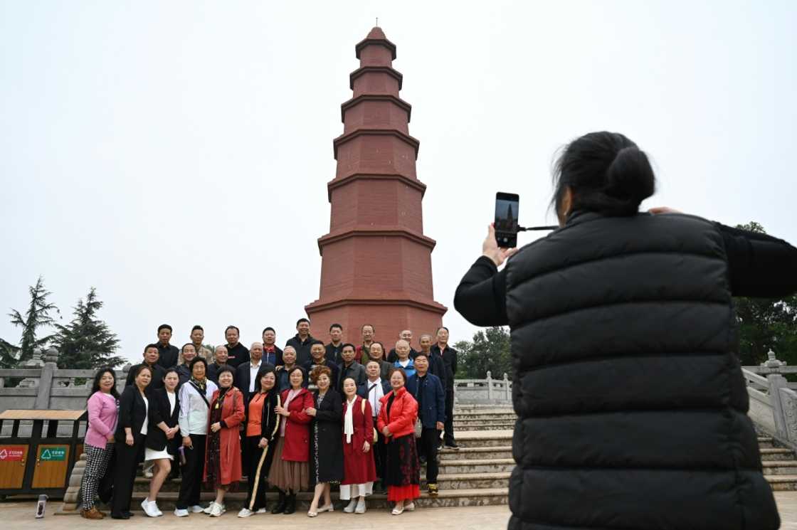 Visitors pose for photos in front of the Hongta, or red pagoda, outside the Tobacco Cultural Center in China's Yuxi Visitors pose for photos in front of the Hongta, or red pagoda, outside the Tobacco Cultural Center in China's Yuxi