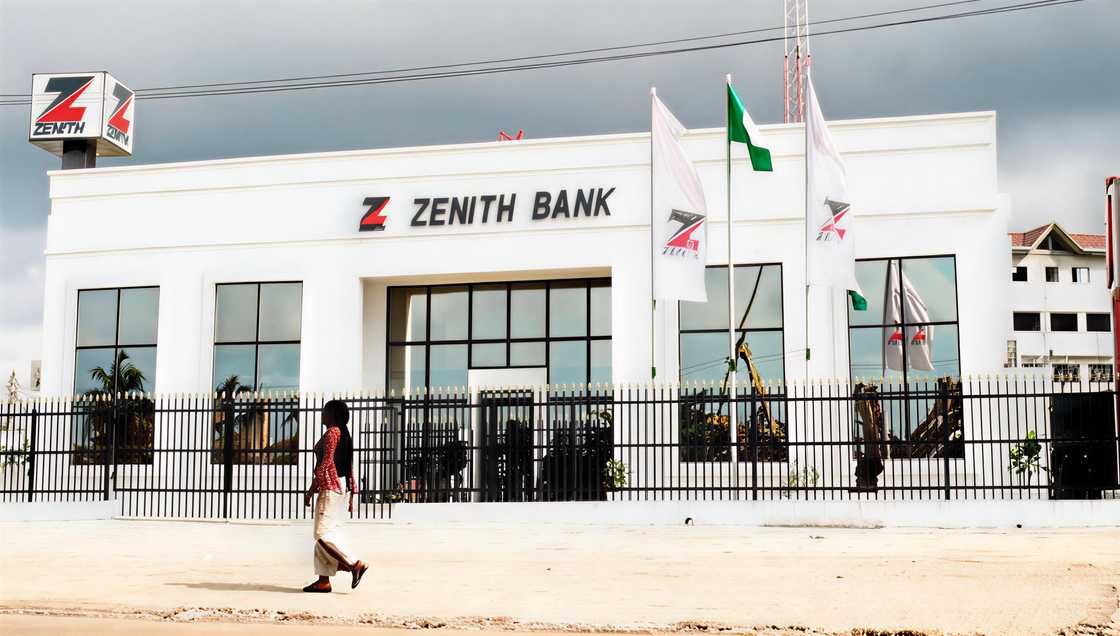 A woman walks past a Zenith Bank branch in Nigeria