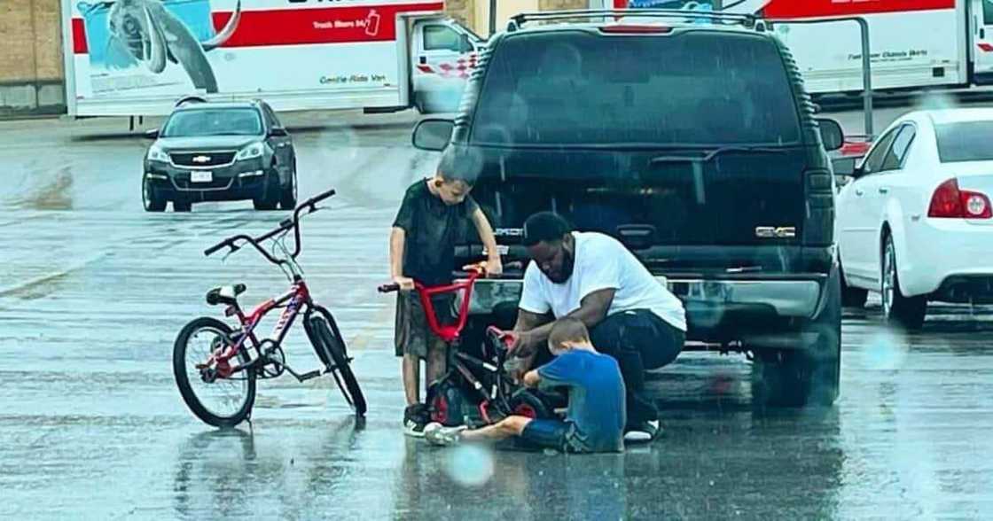 The man had just stepped out of his SUV when he noticed the boy trying to fix his bike. The man had just stepped out of his SUV when he noticed the boy trying to fix his bike.