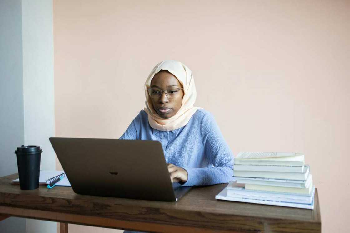 A woman typing on a laptop during a homework preparation.