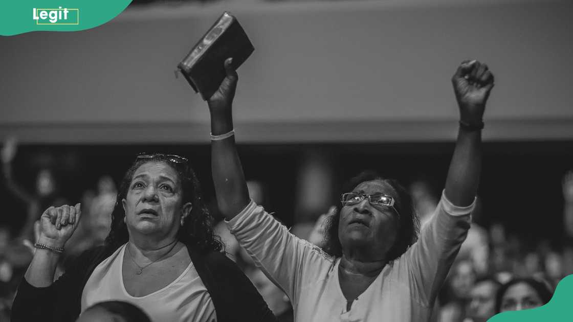 A grayscale photo of people worshiping