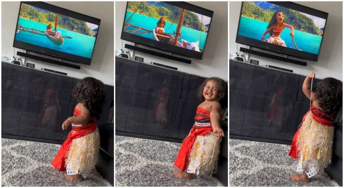 Pretty little girl dresses up like Moana while watching the Disney movie.