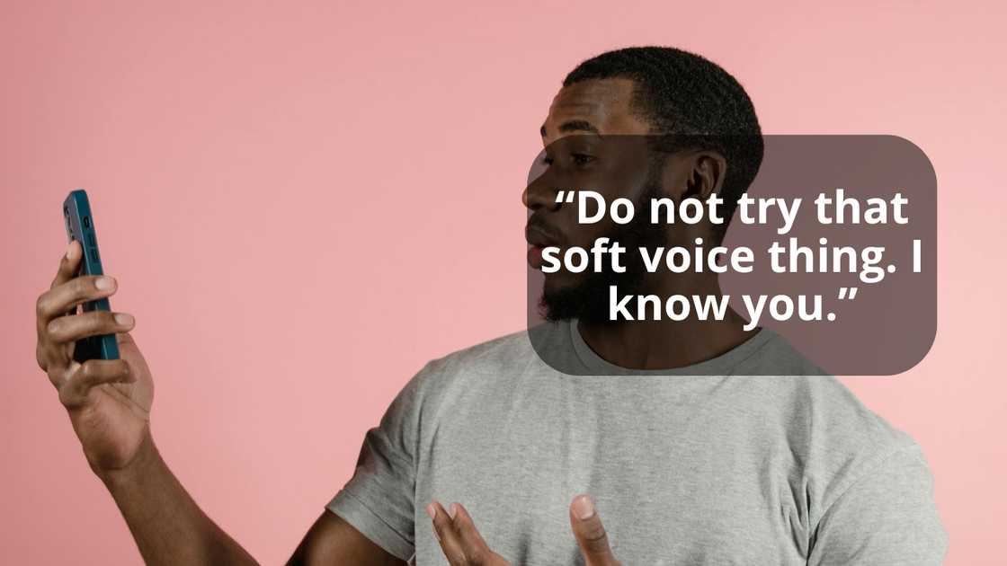 A man looks at his phone with a surprised expression against a pink background. A man looks at his phone with a surprised expression against a pink background.