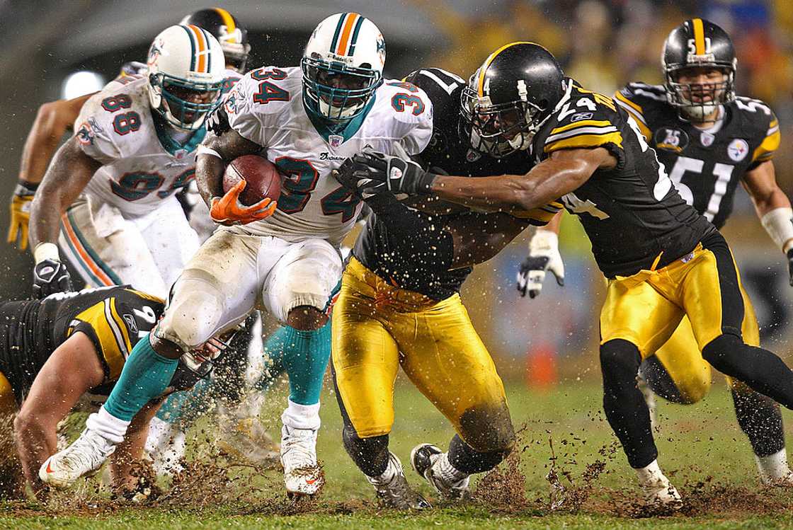 Miami Dolphins' Ricky Williams is tackled by Pittsburgh Steelers linebacker at Heinz Field in Pittsburgh, Pennsylvania