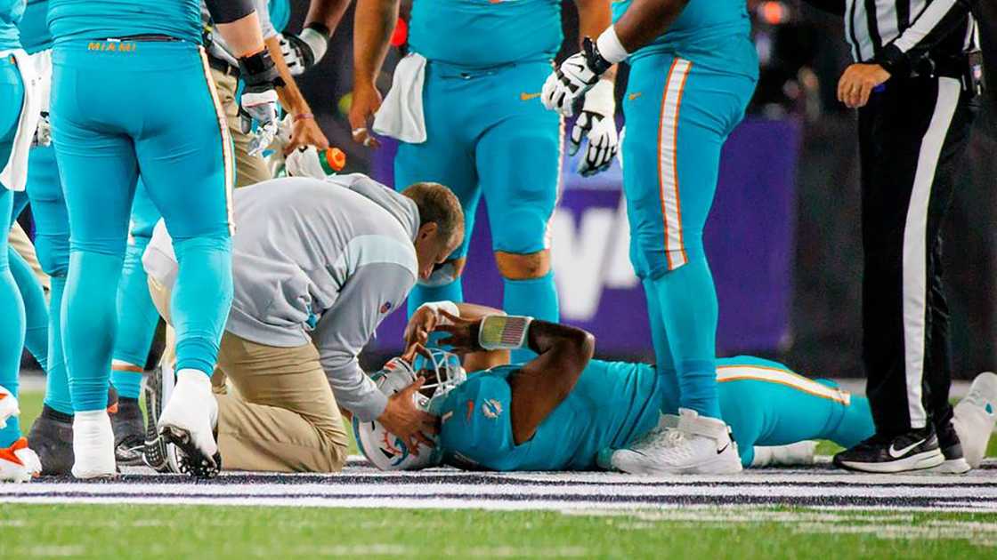 Miami Dolphins' Tua Tagovailoa lays on the ground as medical staff attend to him.