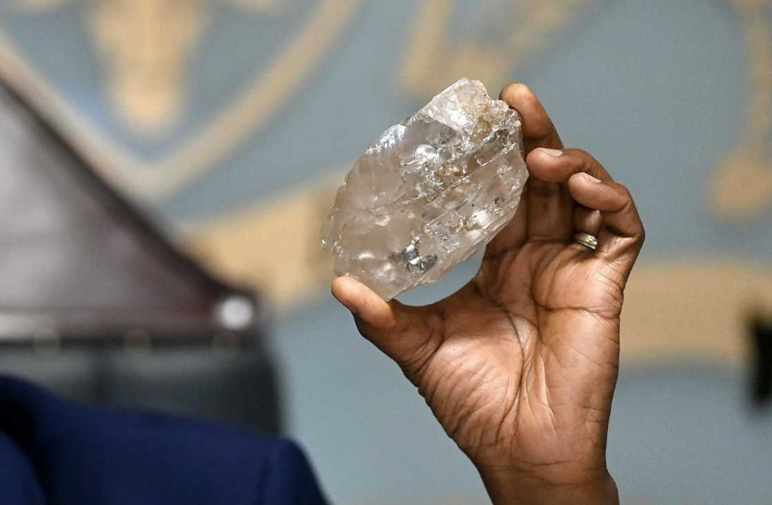 Botswana's President Mokgweetsi Masisi holds a large diamond discovered in Botswana at his office in Gaborone on August 22, 2024