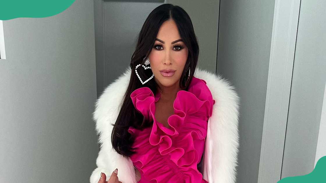 Angie Katsanevas in a vibrant pink ruffled top and a luxurious white fur accessory. Angie Katsanevas in a vibrant pink ruffled top and a luxurious white fur accessory.