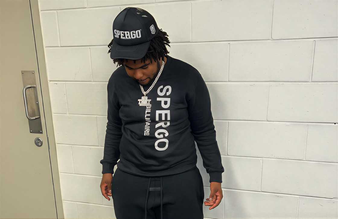 Trey Brown looking down wearing a black SPERGO‍ sweatshirt and pants