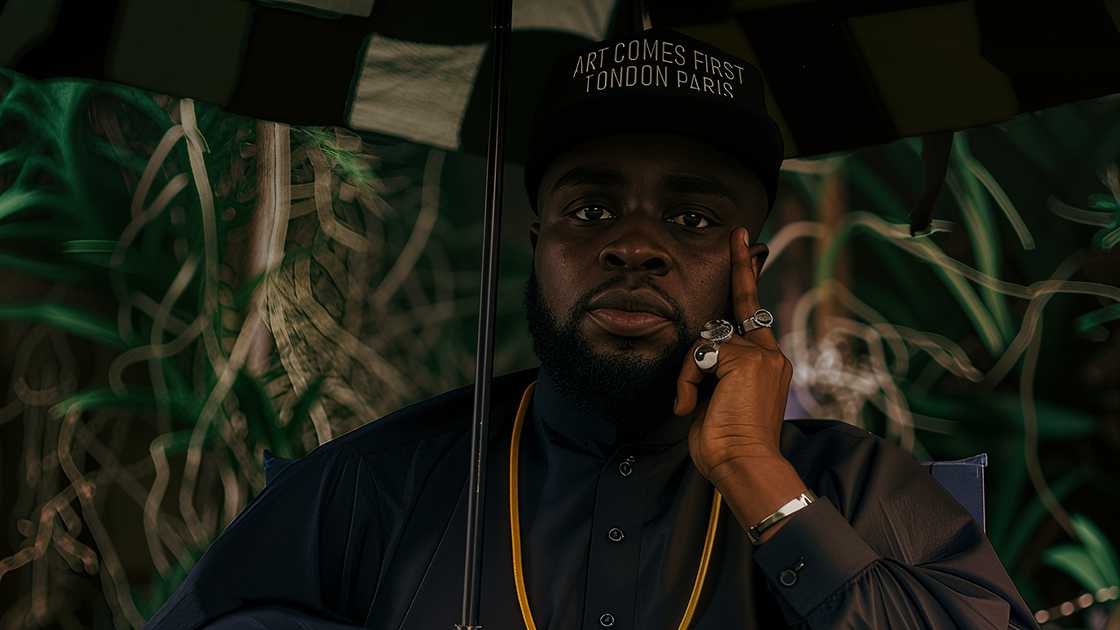 M.anifest holds an umbrella during a shoot for his 2025 album. M.anifest holds an umbrella during a shoot for his 2025 album.