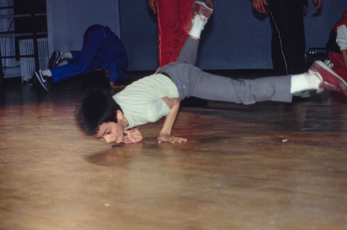 A teen freeze-dancing indoors