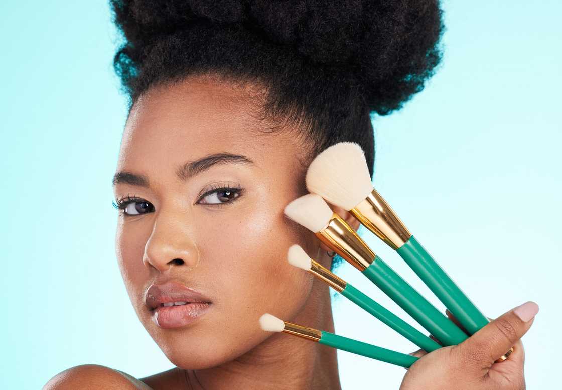 A Nigerian female modelling cosmetic brushes A Nigerian female modelling cosmetic brushes