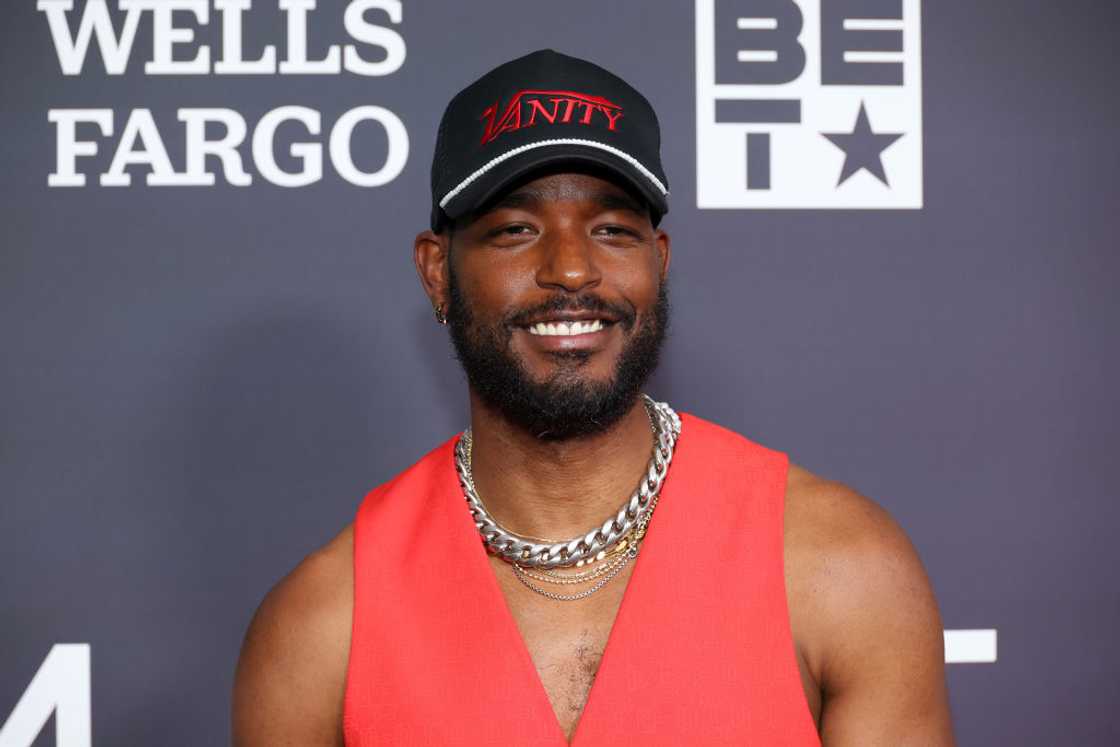 Luke James poses in red and a silver chain