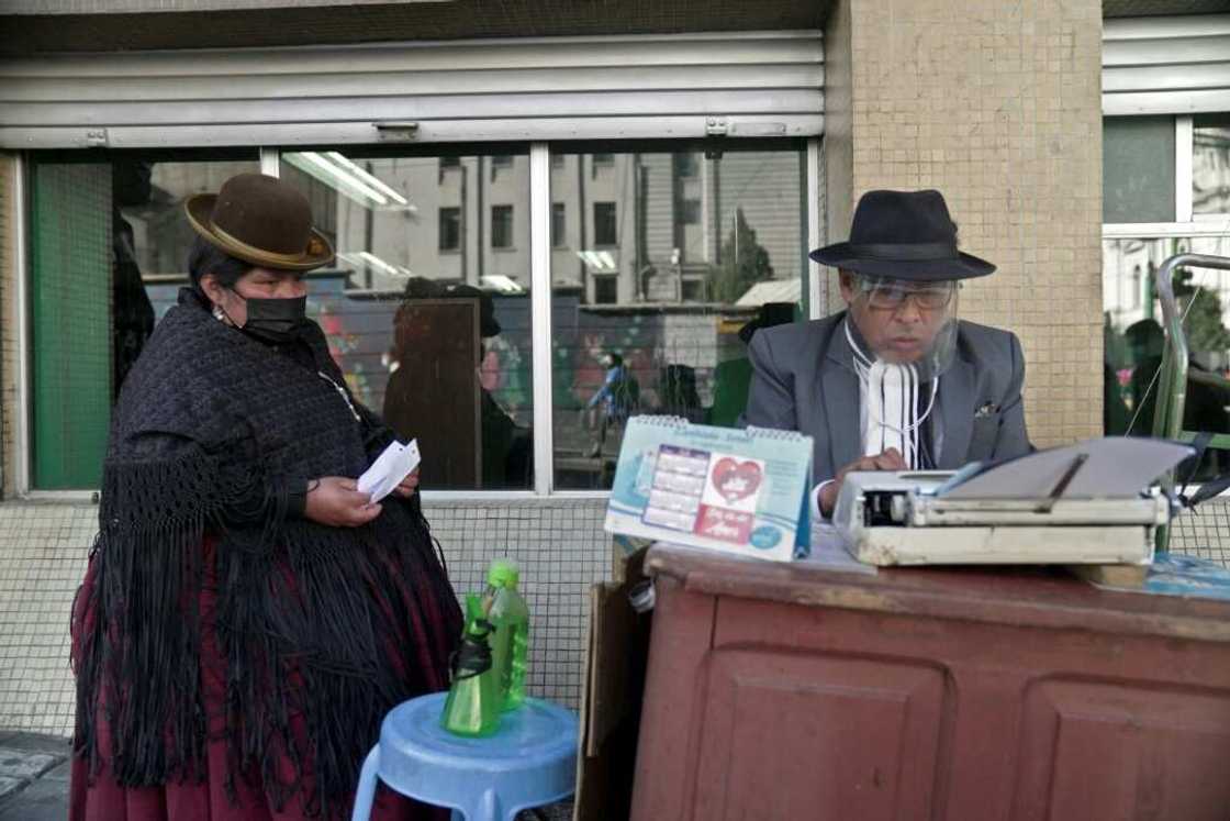 For a fee of up to seven bolivianos (about $1) per page, 'we handle everything related to national taxes,' Rogelio Condori (R) told AFP For a fee of up to seven bolivianos (about $1) per page, 'we handle everything related to national taxes,' Rogelio Condori (R) told AFP