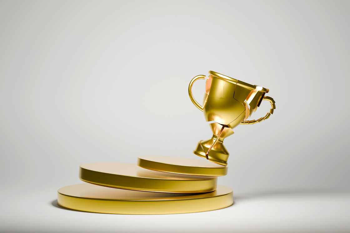 A broken trophy on a podium A broken trophy on a podium