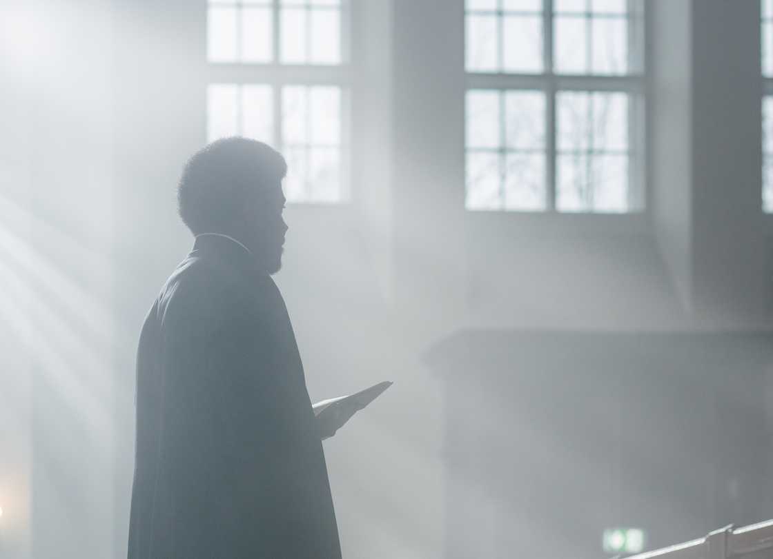 Funeral church scene flashback in soft light.