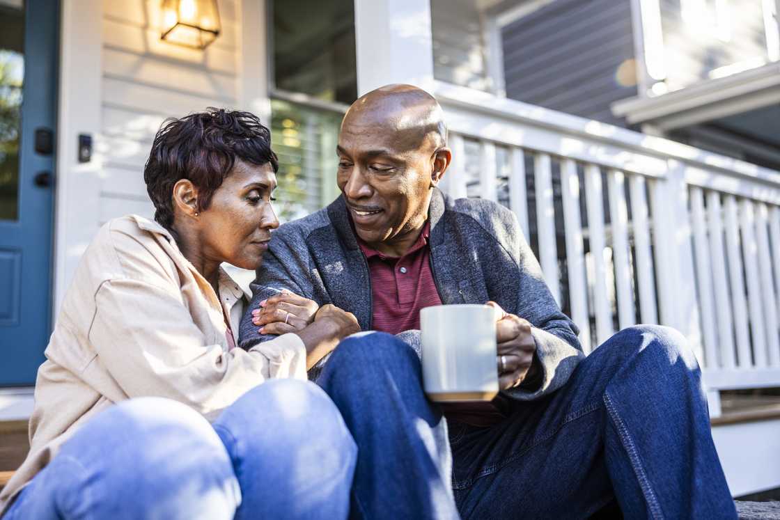 A senior couple having coffee on front porch