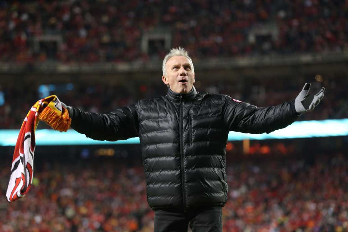 Joe Montana walks on the field holding a flag at Arrowhead Stadium Joe Montana walks on the field holding a flag at Arrowhead Stadium