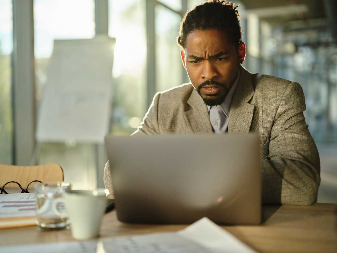 A frustrated man reading a problematic e-mail on a computer in the office. A frustrated man reading a problematic e-mail on a computer in the office.