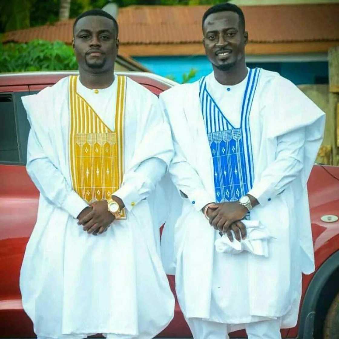 White Agbada styles for guys with blue and yellow ornaments White Agbada styles for guys with blue and yellow ornaments