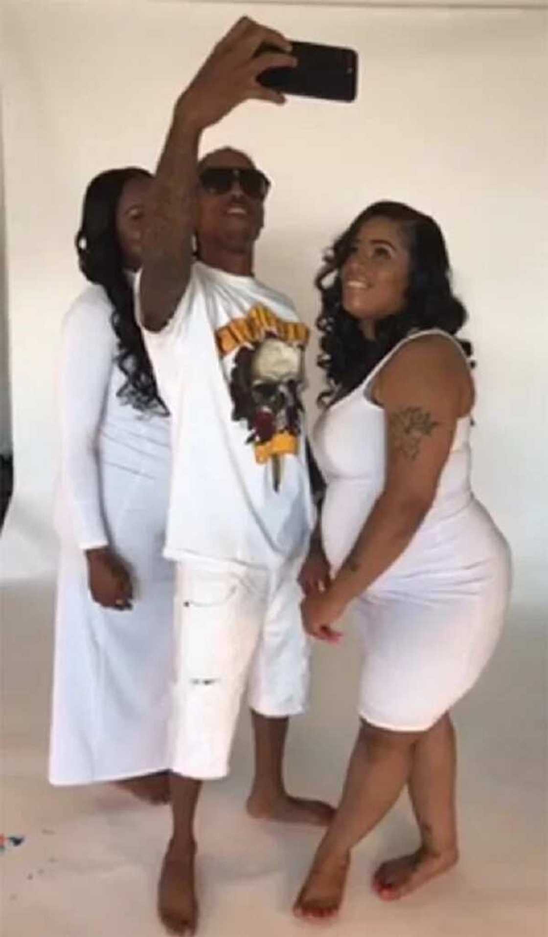 Man poses for pictures with his two pregnant girlfriends Man poses for pictures with his two pregnant girlfriends