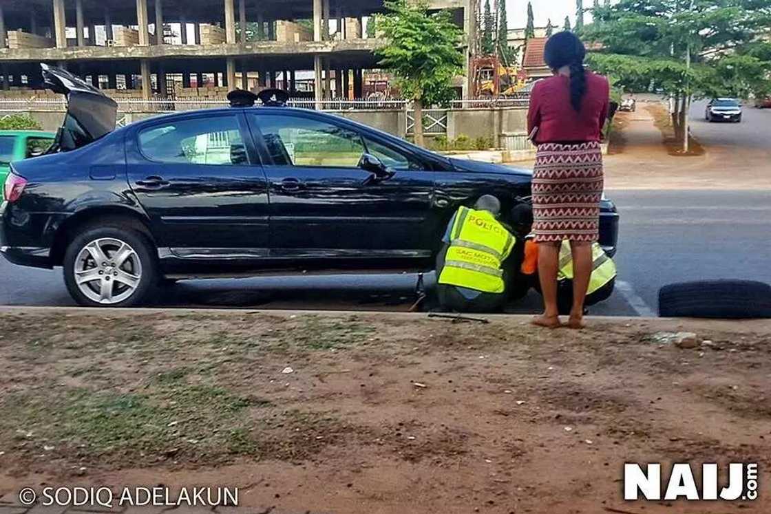Nigerian police officers help a lady in distress, fix her car in Abuja (photo) Nigerian police officers help a lady in distress, fix her car in Abuja (photo)
