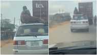 Nigerian man travelling by road from Akure seen sitting on roof of car, video stirs reactions