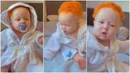 Cute albino baby with flawless skin plays on mum's bed, video trends online, women praise child