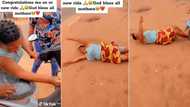 Appreciative mother rolls on the floor as son gifts her brand new motorcycle