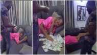 Nigerian man spoils his wife, sprays dollars on her while she's sleeping, many people react to sweet video