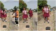 Young man puts Bluetooth speaker in front of girl dressed in school uniform, she dances without thinking twice