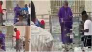 Priest confused as young boys gather and throw money on him at the altar in viral video, Nigerians react