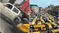 Only in my city: Man hangs like Spider-Man to repair a moving yellow Danfo bus in Lagos, video stirs reactions