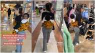 Pretty oyinbo lady backs baby with Nigerian wrapper, people keep looking at her, video goes viral