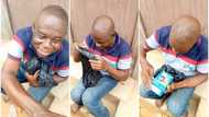 Proud Nigerian dad opens black waterproof with serious joy as his son gifts him new phone, video goes viral
