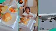 Funny little girl enjoys meal on the airplane, her blissful experience captured